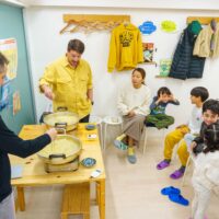 鍋でうどんを茹でている様子を、参加者が席から見守っている場面 手打ちうどん作り体験教室 2025年12月 A6407391-1-scaled.jpg – イリコスキー製麺所