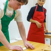 麺棒を使って生地を丁寧に伸ばしていく様子。 / Carefully flattening the dough using a rolling pin. 手打ちうどん作り体験教室 2026年1月 A6407930-1-scaled.jpg – イリコスキー製麺所