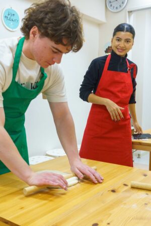 麺棒を使って生地を丁寧に伸ばしていく様子。 / Carefully flattening the dough using a rolling pin. 手打ちうどん作り体験教室 2026年1月 A6407930-1.jpg – イリコスキー製麺所