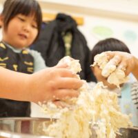 小麦粉と塩水を混ぜて手がべちゃべちゃになっている手元のアップ(Close-up of sticky hands mixing flour and saltwater) 手打ちうどん作り体験教室 2026年1月 A6408391-0-scaled.jpg – イリコスキー製麺所