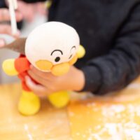 うどんの仕上げを一緒にお手伝いしてくれるアンパンマンのぬいぐるみ。 / An Anpanman plushie helping with the final steps of udon making. 手打ちうどん作り体験教室 2026年2月 A6408710-1.jpg – イリコスキー製麺所