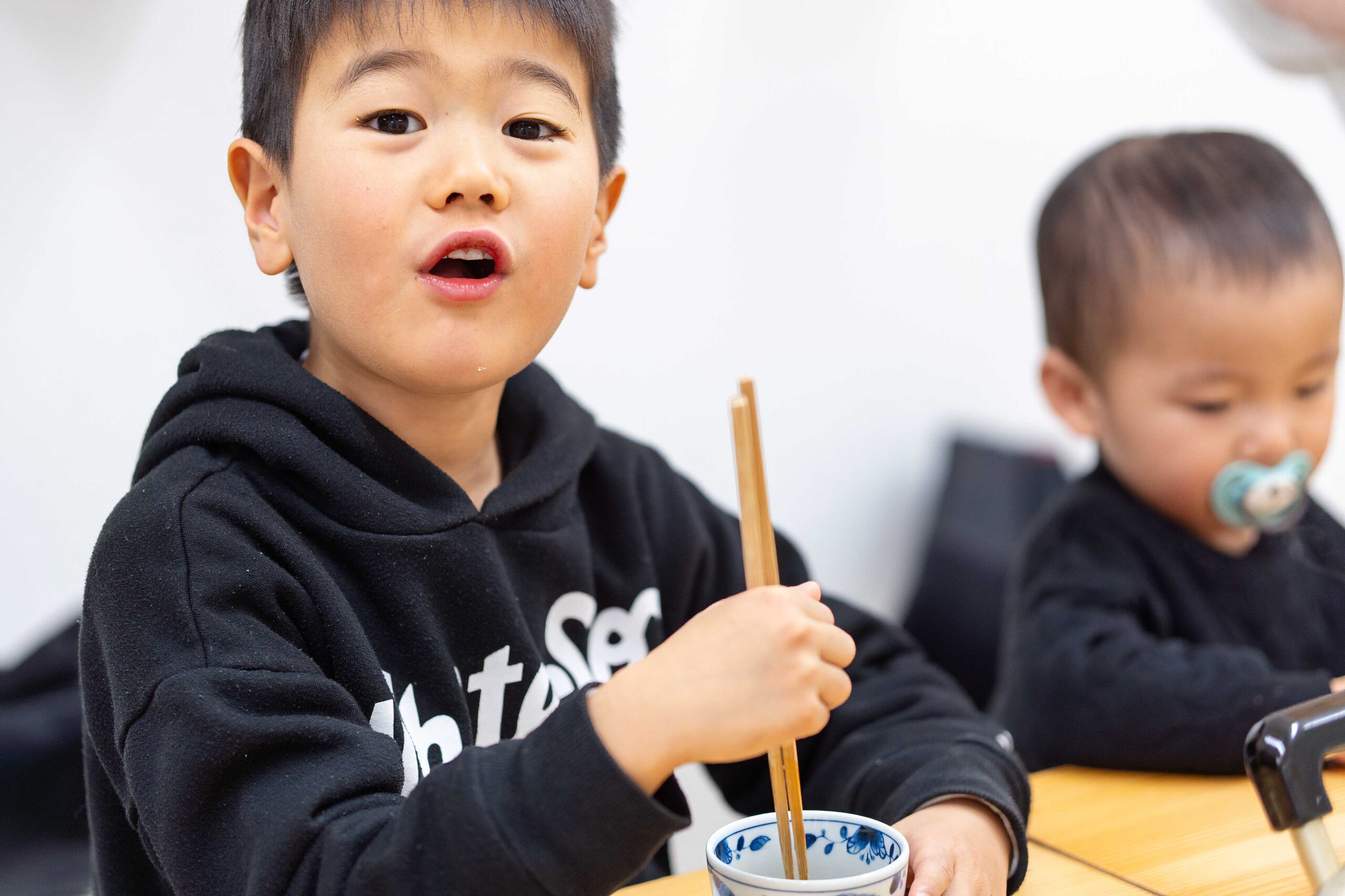 自分で作ったうどんを前に、達成感いっぱいの表情を見せる男の子。 / A boy looking proud in front of the udon he made himself. A6408659-1.jpg 手打ちうどん作り体験教室 2026年2月 A6408733-1-scaled.jpg – イリコスキー製麺所