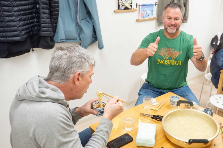 大阪のうどん体験教室でできたてのうどんを前に両手でサムズアップする男性 手打ちうどん作り体験教室 2026年1月 udon-class-thumbs-up.jpg – イリコスキー製麺所