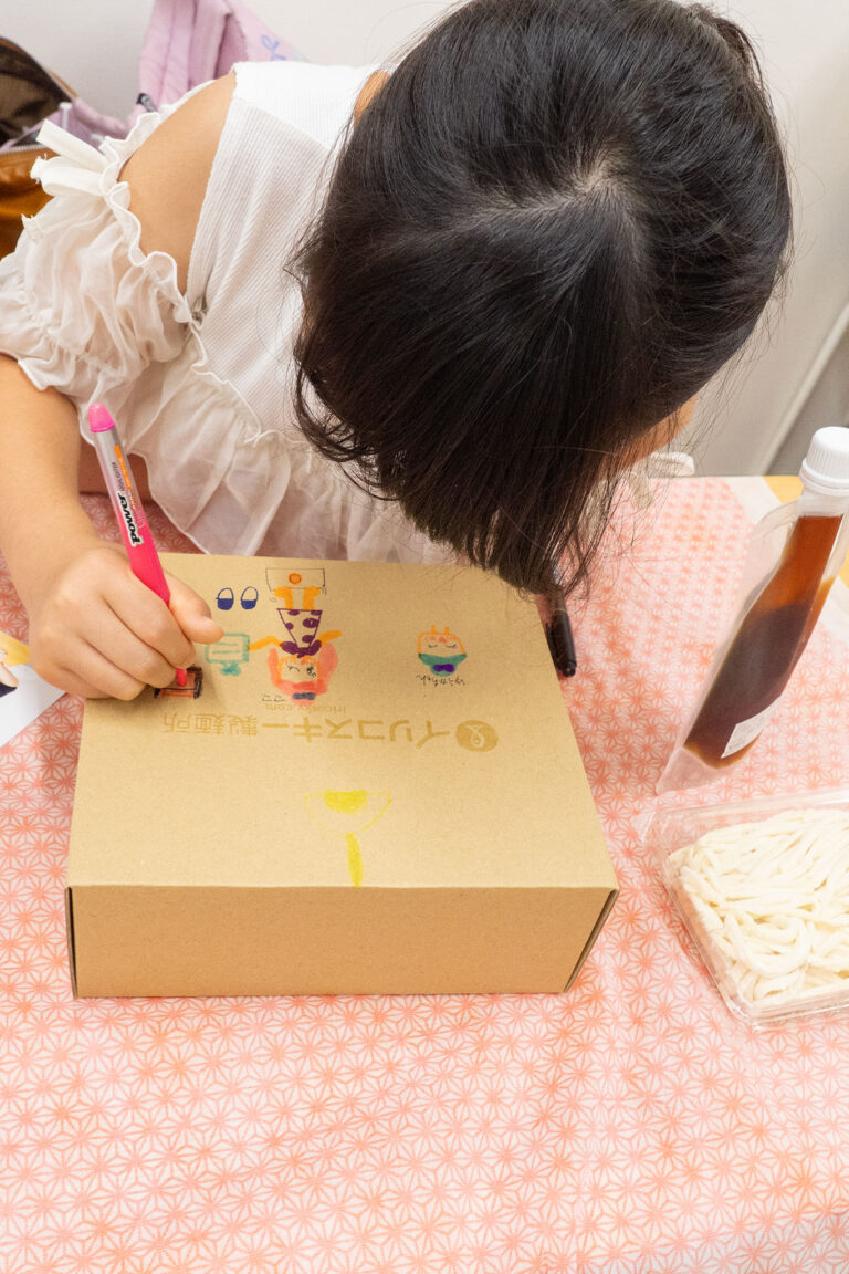 父の日のうどんプレゼントボックス 手打ちうどん作り体験教室 2026年3月 udon-class-girl-decorating-present-box-colorful-pens.jpg – イリコスキー製麺所