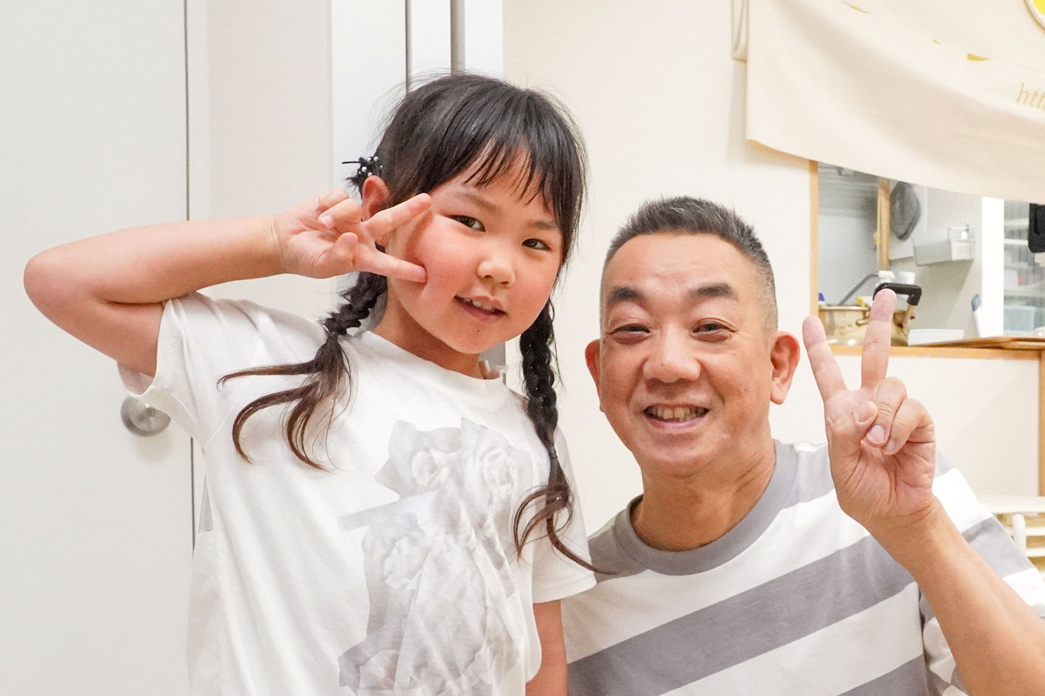 女の子と所長がピースサインで記念撮影。 手打ちうどん作り体験教室 2026年6月 udon-class-girl-instructor-peace-sign.jpg – イリコスキー製麺所